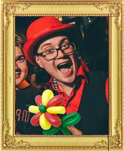 Cute clown circus acts for hire London and Brighton, laughing balloon modeller with balloon flower