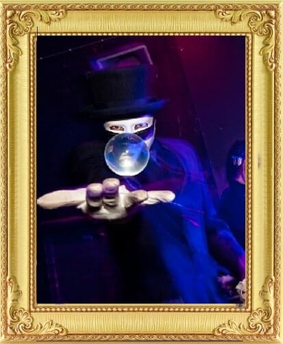Masked crystal ball juggler makes a ball float bespoke unique entertainment in London and Brighton