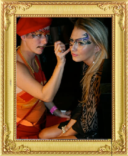 face-painter paints beautiful design on a ladies face from our entertainment agency Brighton