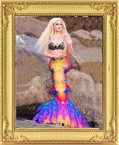 Bespoke unique entertainment mermaid performer sitting on rock with beautiful coloured tail