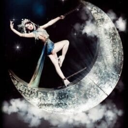 Burlesque dancer performer with glitter moon swing in London