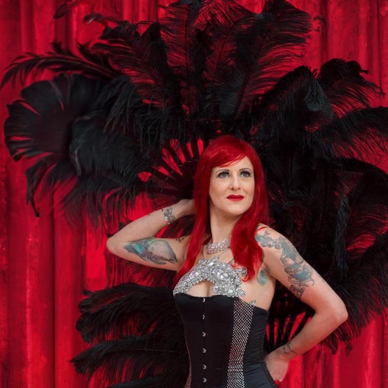 cabaret theme party ideas blog image with a Burlesque dancer holding black fans in London